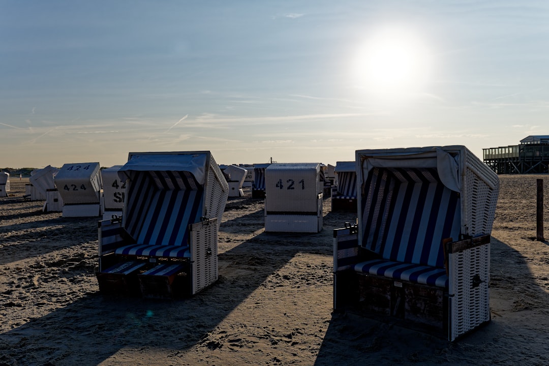 A row of beach chairs sitting on top of a sandy beach